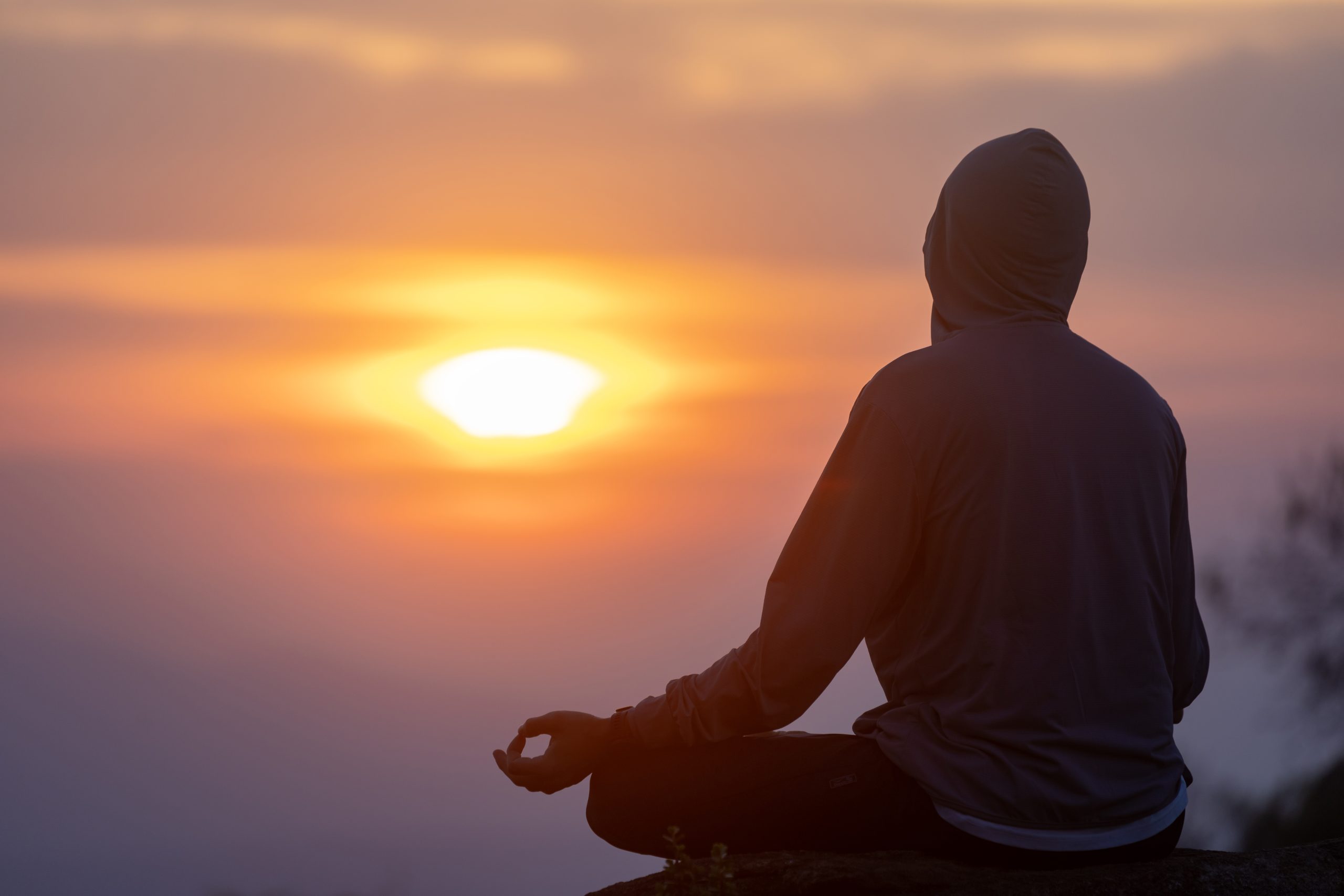 Person meditating in nature during a personal meditation retreat.